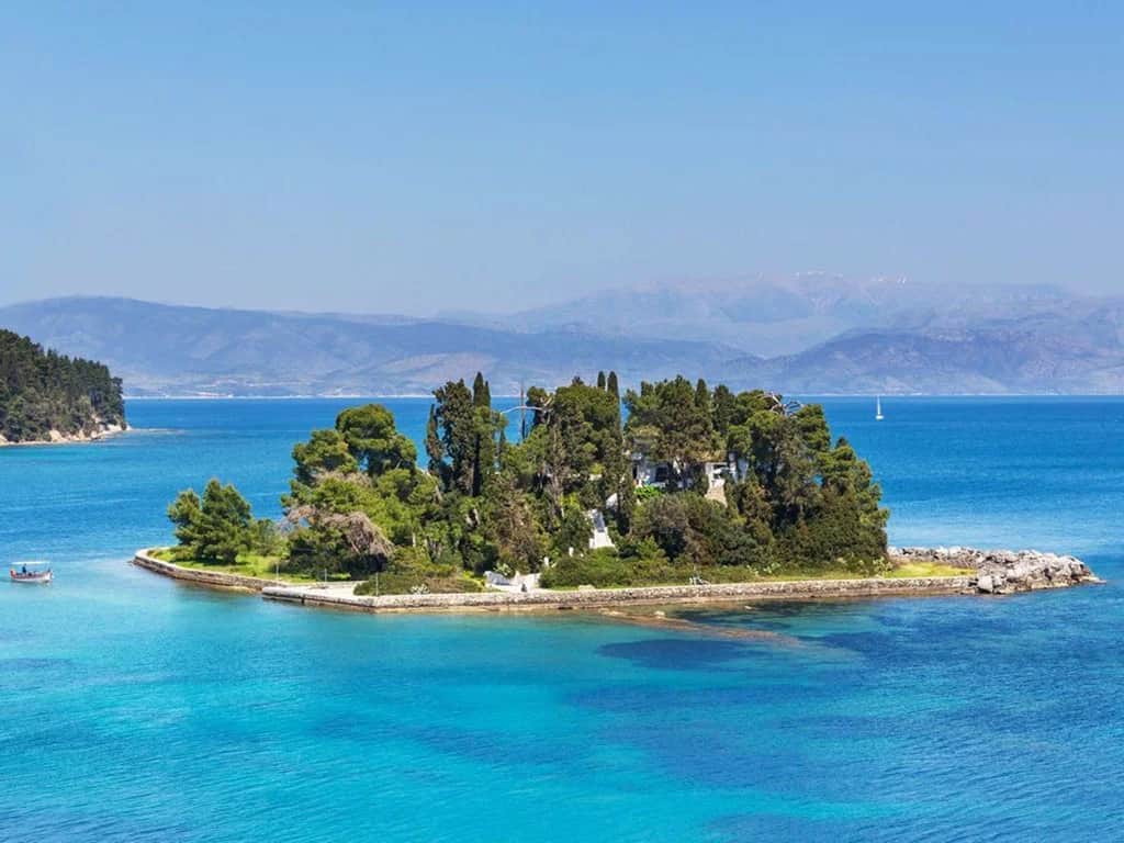 A Corfu beach with clear turquoise sea and blue summer skies